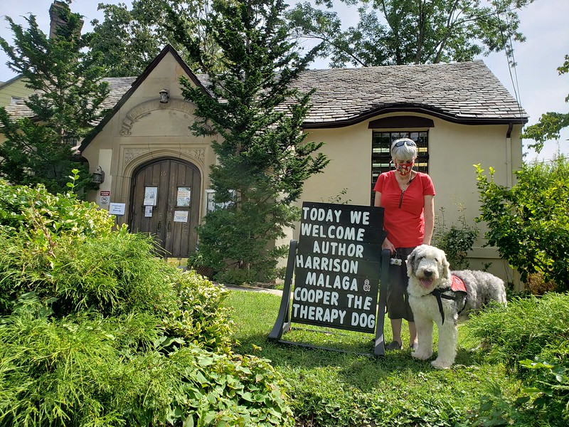 Cooper the Therapy Dog standing outside of the Crestwood Library with his owner.