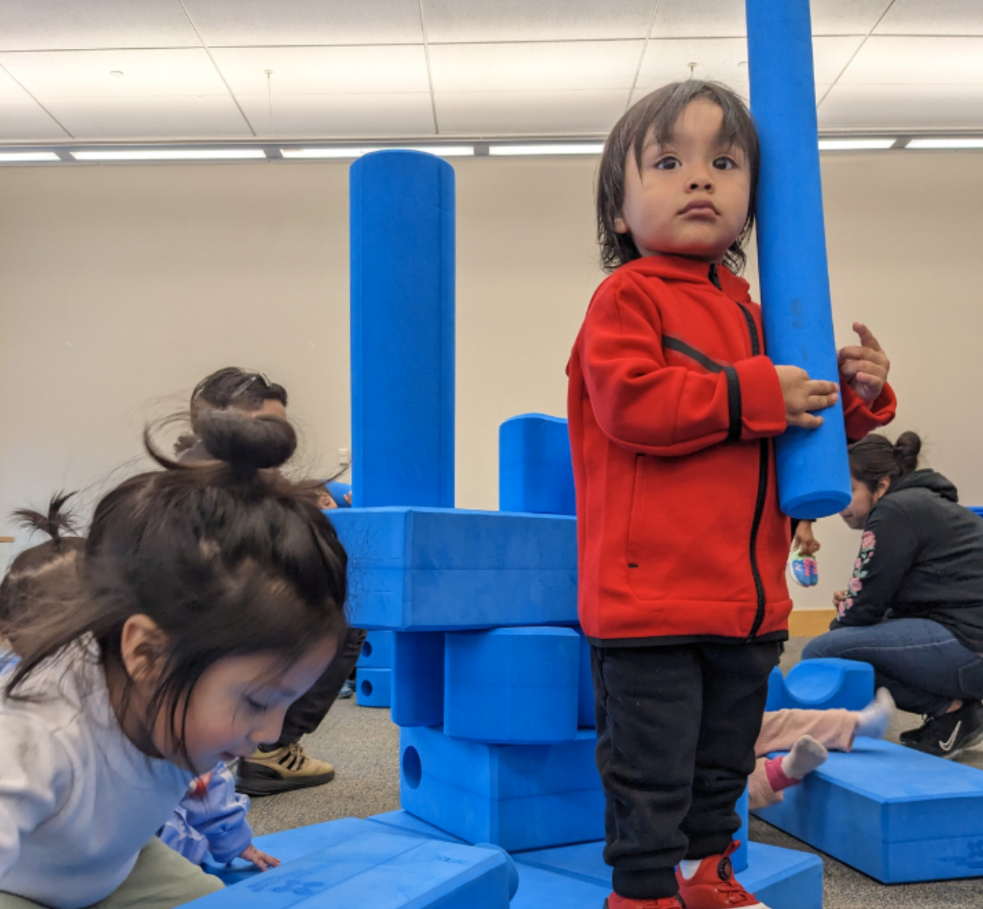Children play with big blue blocks