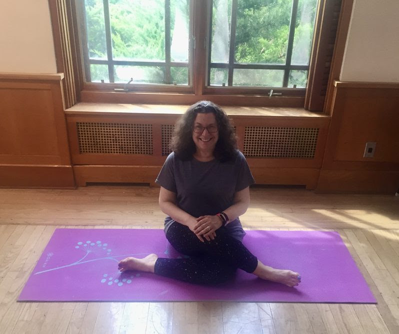 Image of Louise Fecher sitting on a yoga mat