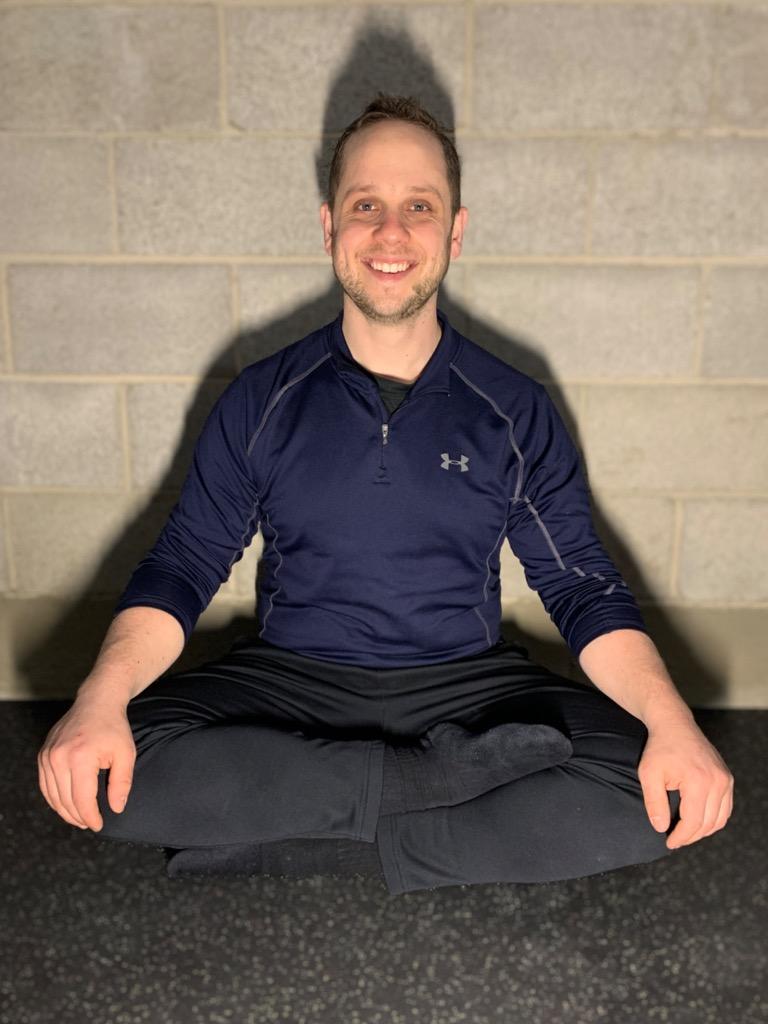 Image of Coach Mike sitting in a Yoga pose