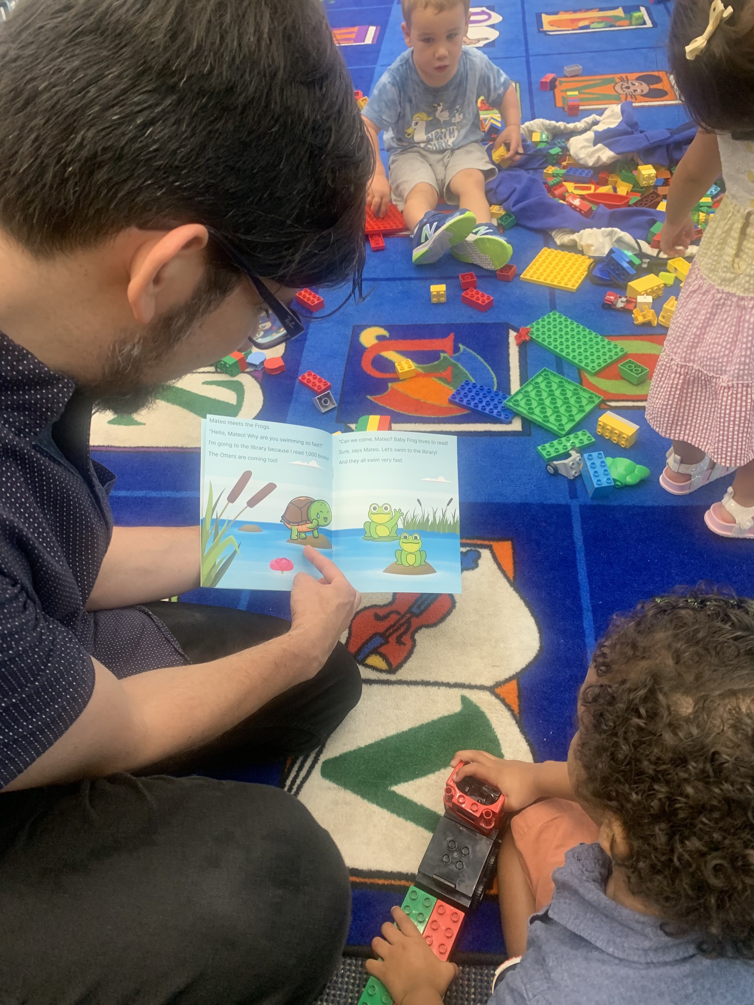 Mateo and his father read together at the Will Library