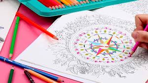 hand holding a color pencil and coloring a coloring sheet