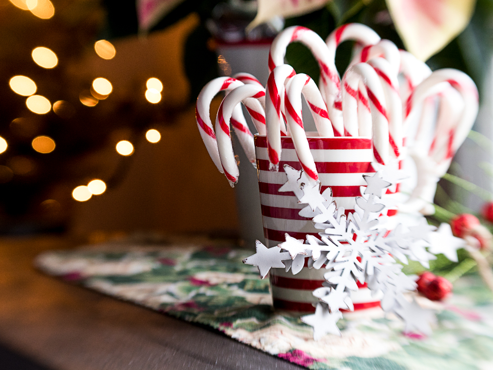candy canes in a red and white striped jar