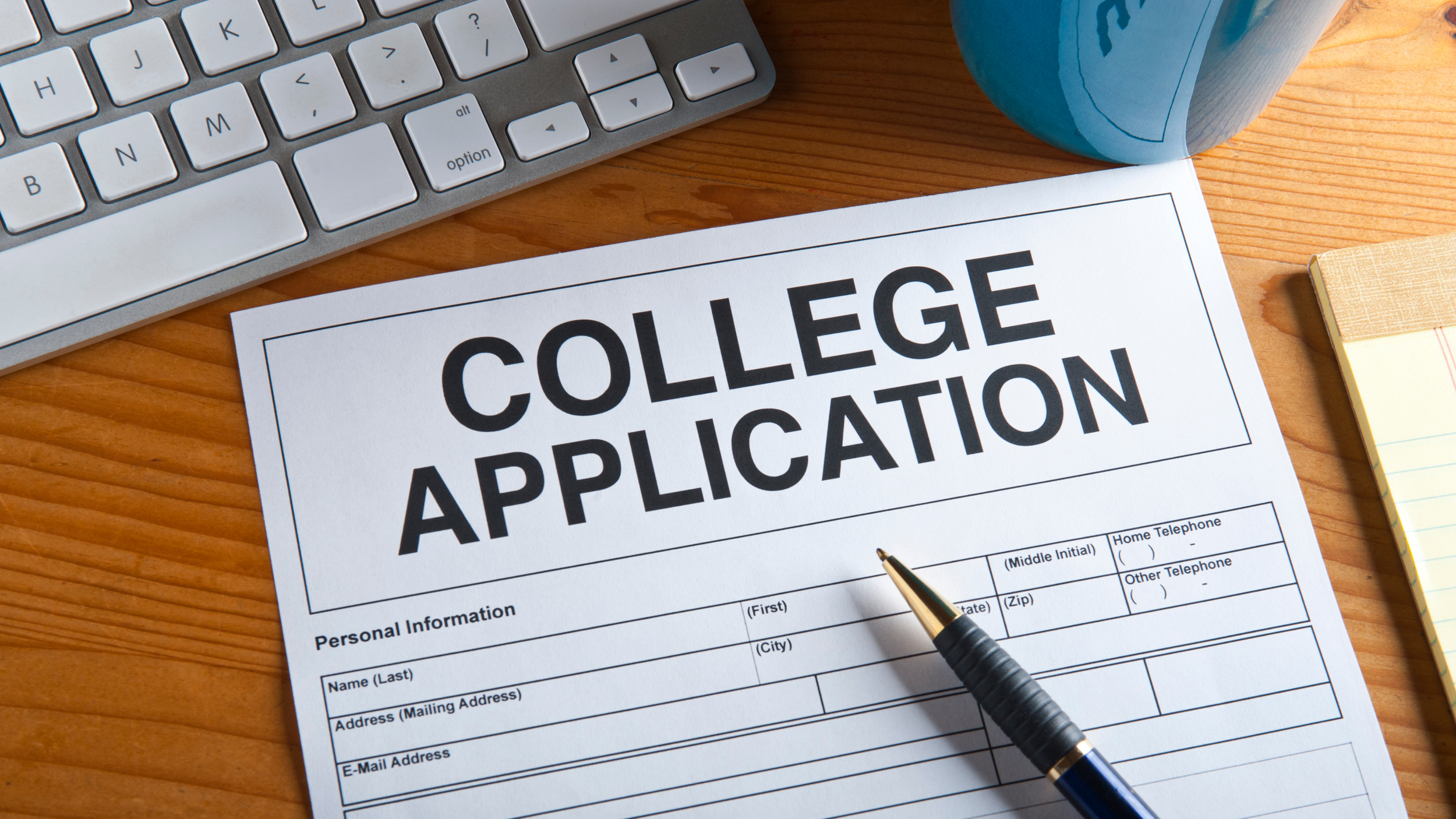 computer and pen on a college application form