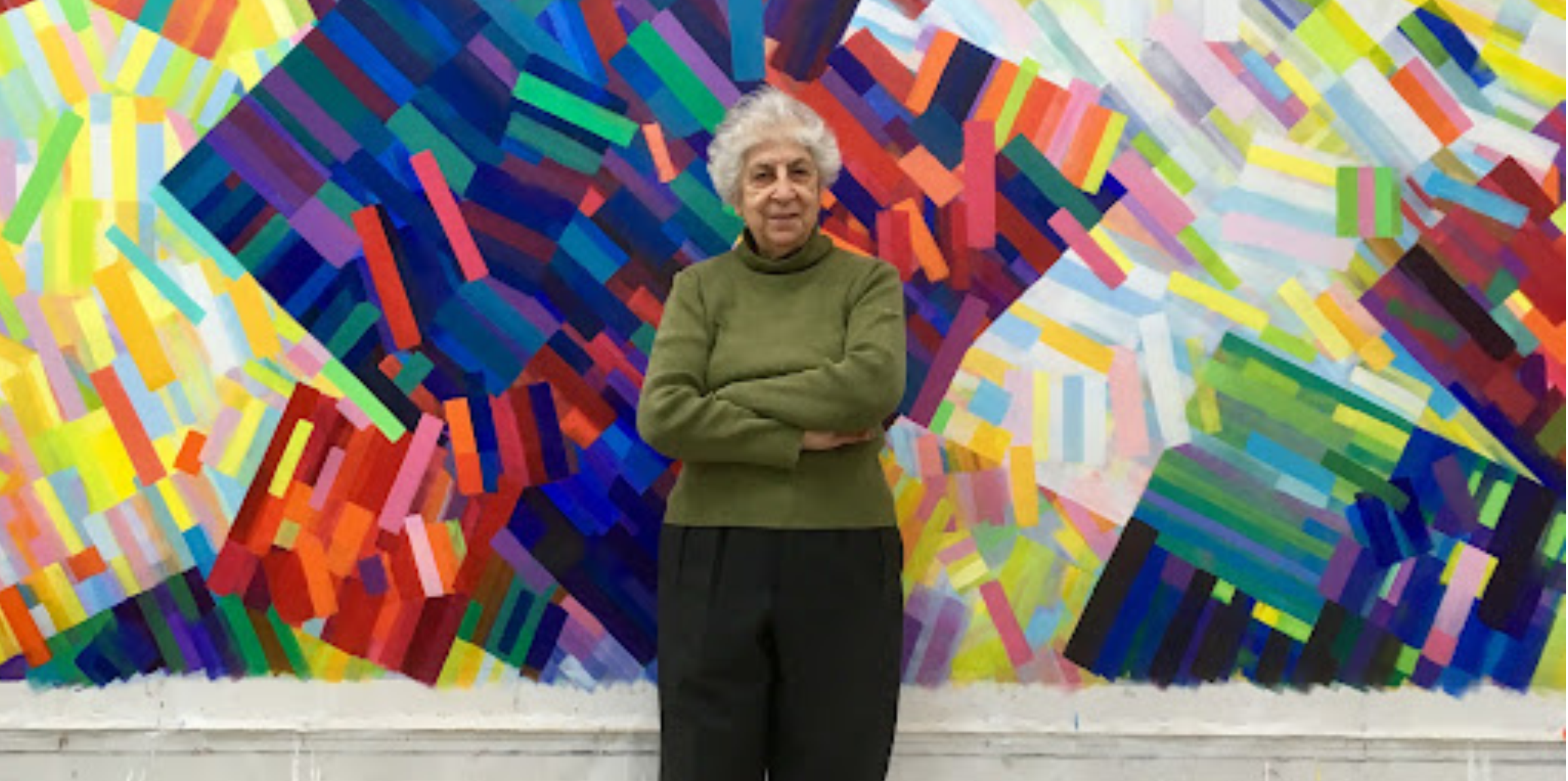 artist Samia Halaby stands in front of her art