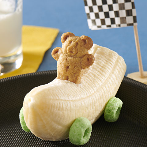 edible racecar made from bananas and cheerios for wheels with a teddygram on top