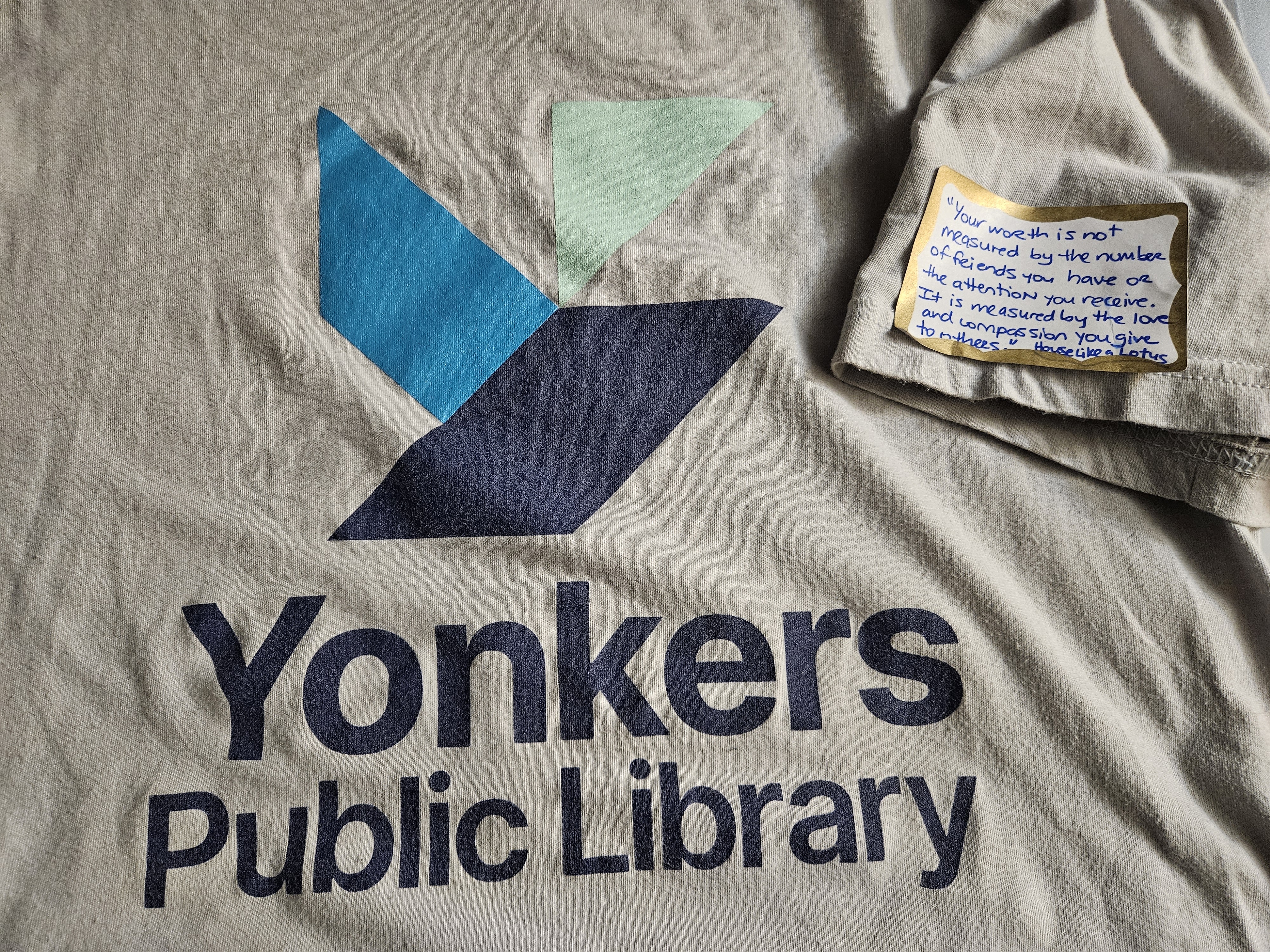 The Yonkers Public Library staff t-shirt with a book quote sticker on the sleeve.
