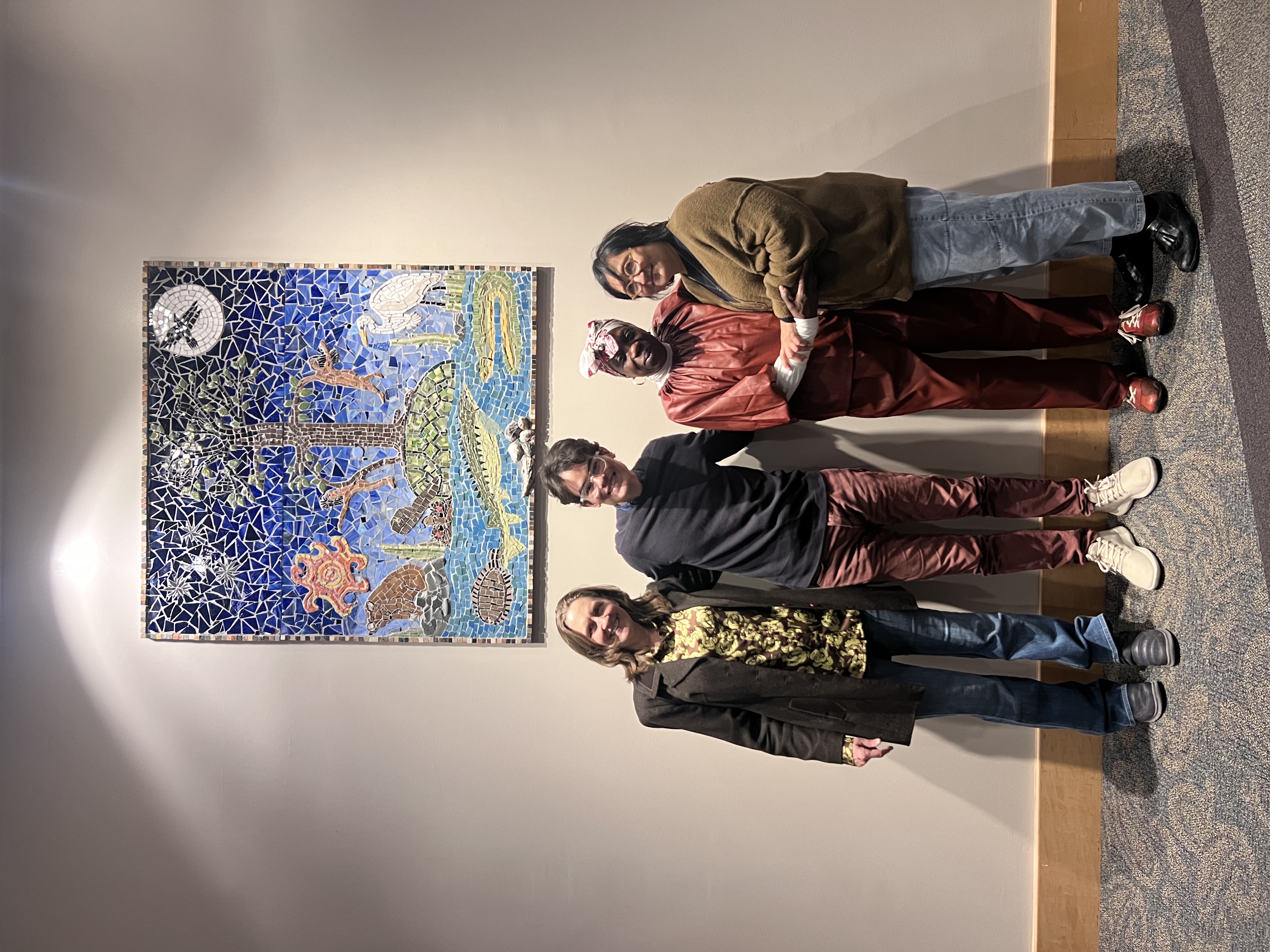 The artists pose in front of the unveiled mosaic on November 18, 2024.