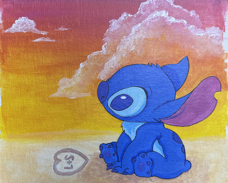 Disney Stitch sittting on a beach during a sunset.