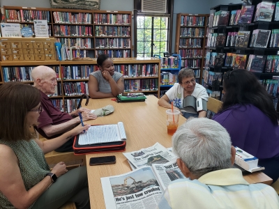 A group of seniors sitting at a table at the Crestwood Library during a NNORC Consultation session.
