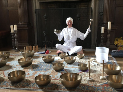 Michelle Clifton with her Tibetan Sound Bowls laid out on the ground in front of her.