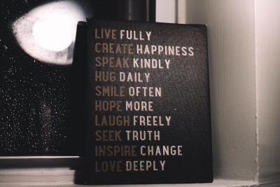 A canvas with the words: live fully, create happiness, speak kindly, hug daily, smile often, hope more, laugh freely, seek truth, inspire change and love deeply.