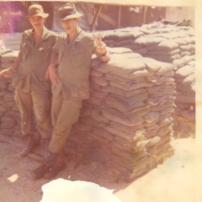 two Vietnam War veterans. One is giving a peace symbol.