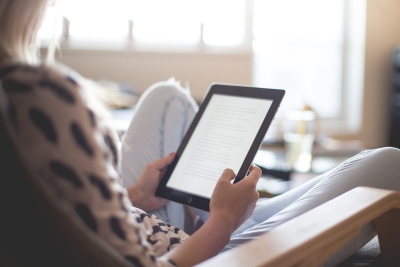 A woman reading an ebook on her tablet device.