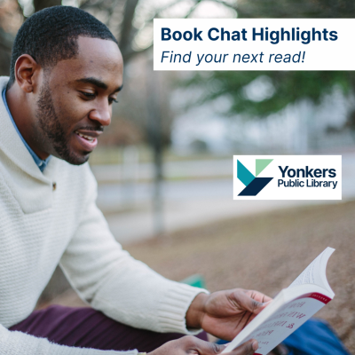 A man reading a book outside at a park.