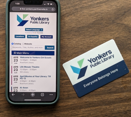 Smartphone with YPL.org on screen and new YPL library card on desktop