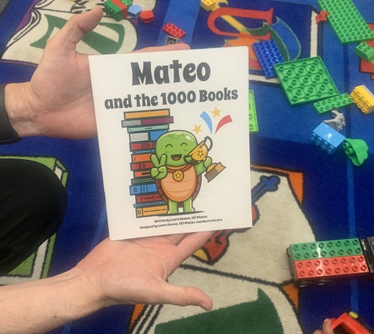 Hand holding a book with a turtle titled "Mateo and the 1000 Books"