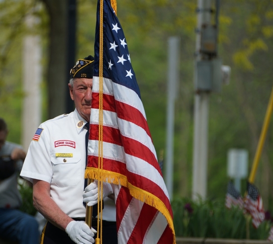 A member of the United States Honor Guard holding an American flag.