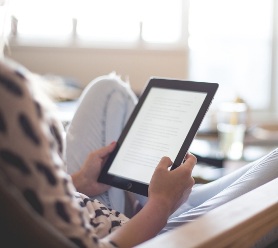 A woman reading an ebook on her tablet device.