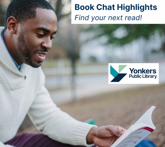 A man reading a book outside at a park.