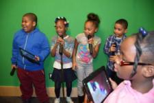 Children singing and recording in the media lab.