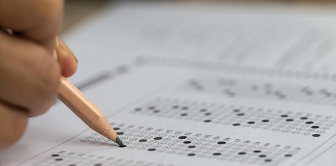 Hand with pencil filling in answer key