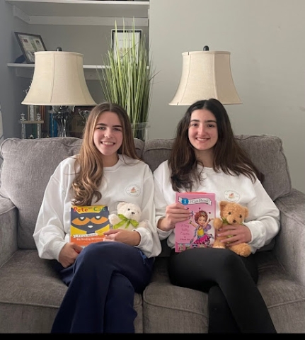 Lauren and Peyton sitting holding books and teddy bears