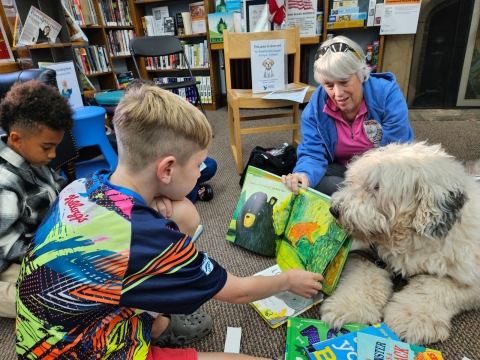 children reading to Cooper the dog