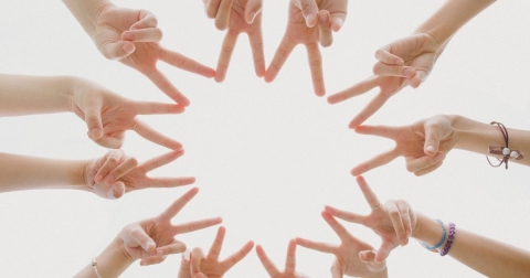 photo of hands in peace signs with fingers touching one another to make a star shap