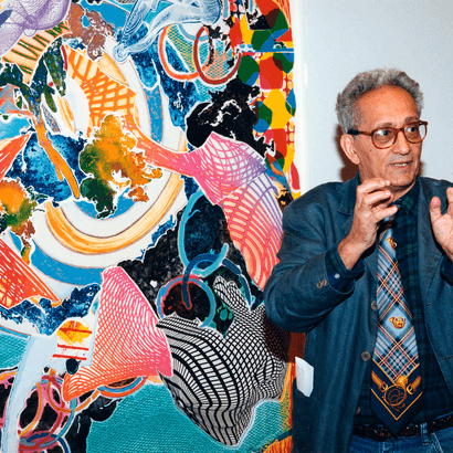 Italian American Artist Frank Stella standing in front of a painting
