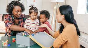 Two parents talking while their children play.