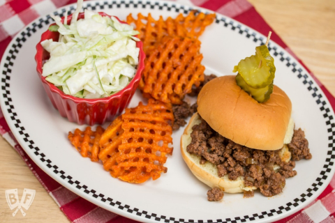 image of sloppy Joe sandwich with creamy coleslaw and waffle potatoes