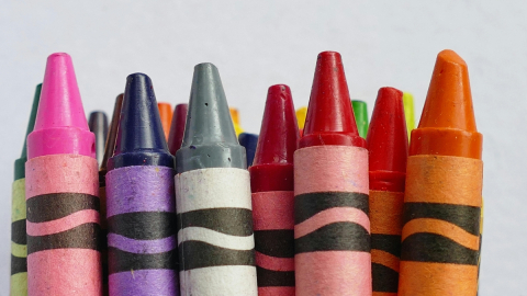 A close up image of the top half of crayons. The crayons are of various colors.