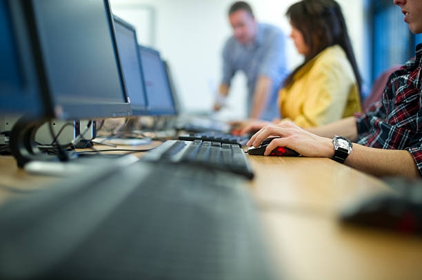 People seated at computers in classroom setting