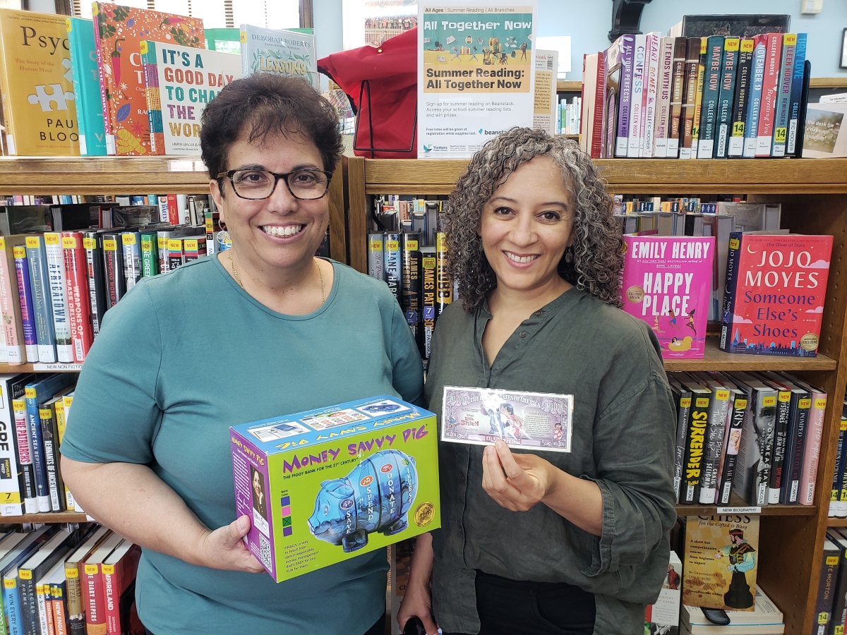 Photo of Sally Pinto and Prima Marte holding a piggy bank and money
