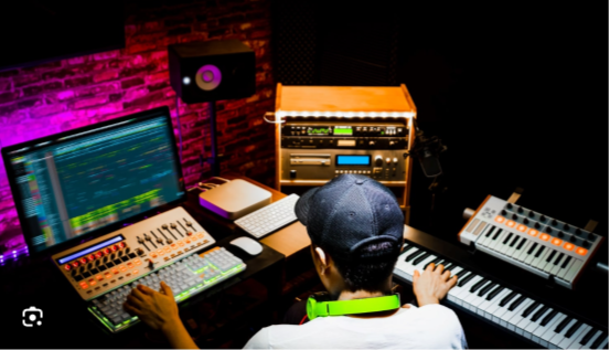 teen sitting at keyboard and computer making music