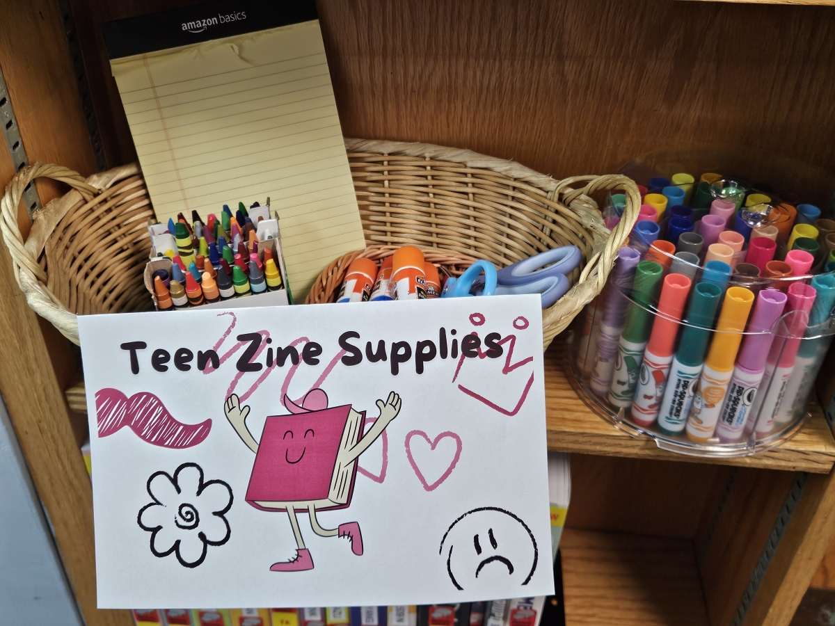 photo of a basket with crayons, paper, scissors, glue and markers