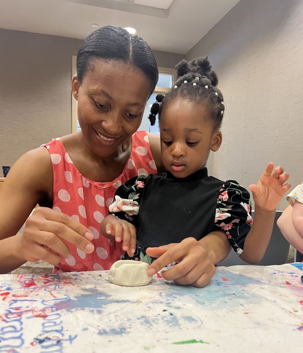 Mother and daughter working on a clay bowl together