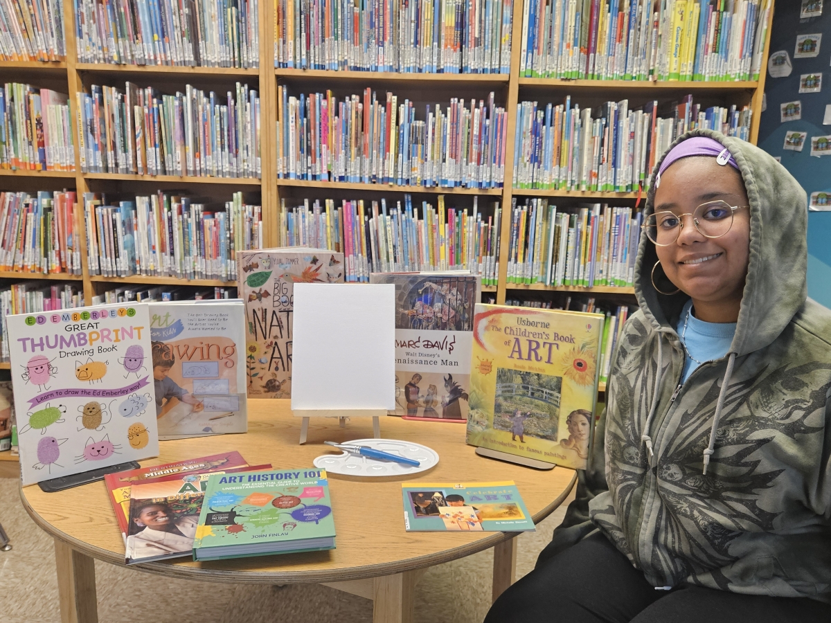 Say surrounded by art books and a plain canvas