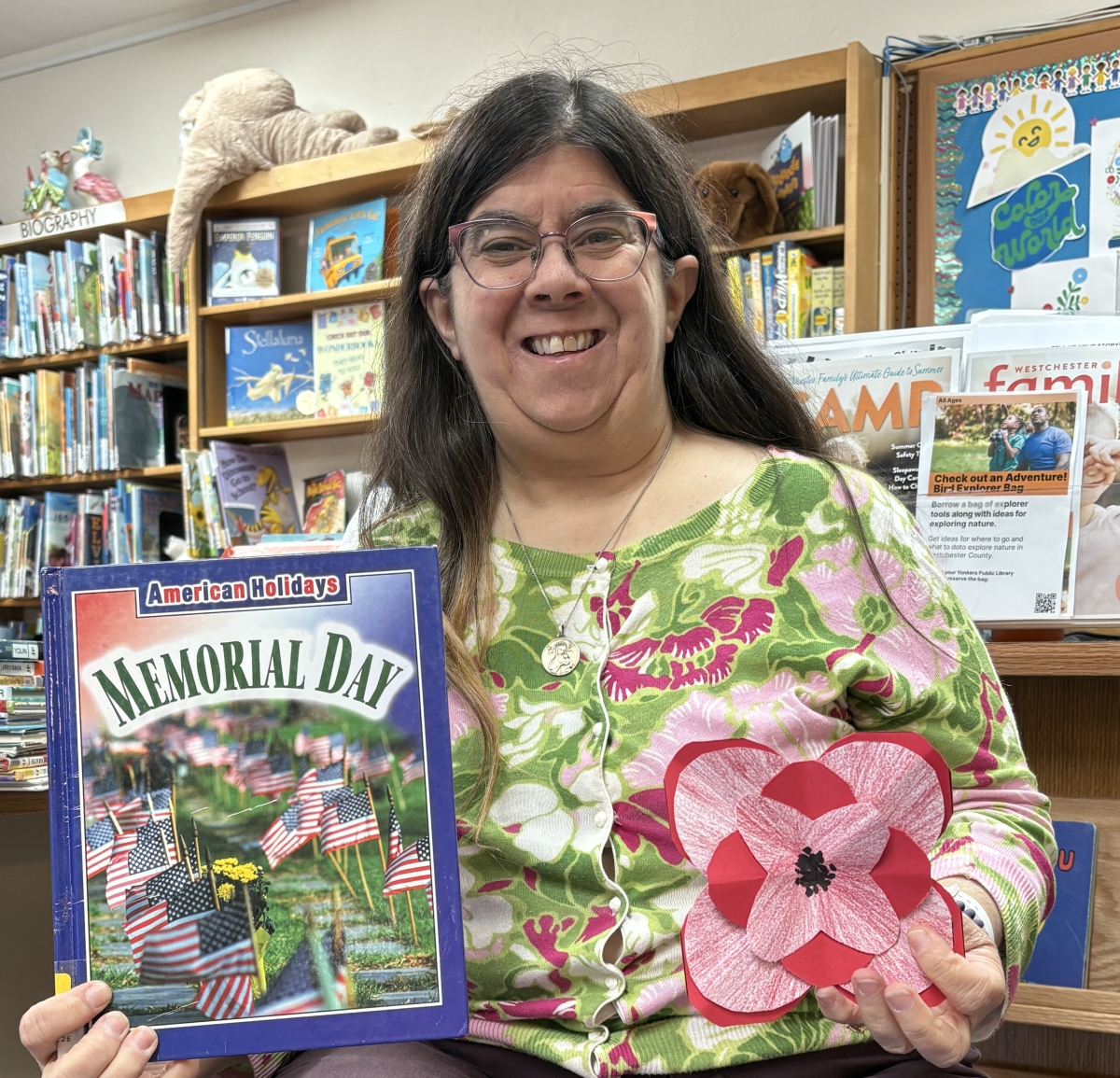 Nancy Wissman holding a memorial day book and sample of Memorial Day Craft