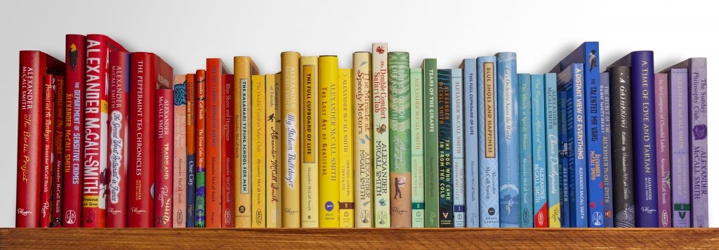 books arranged on a shelf by color red yellow green blue and purple book spines