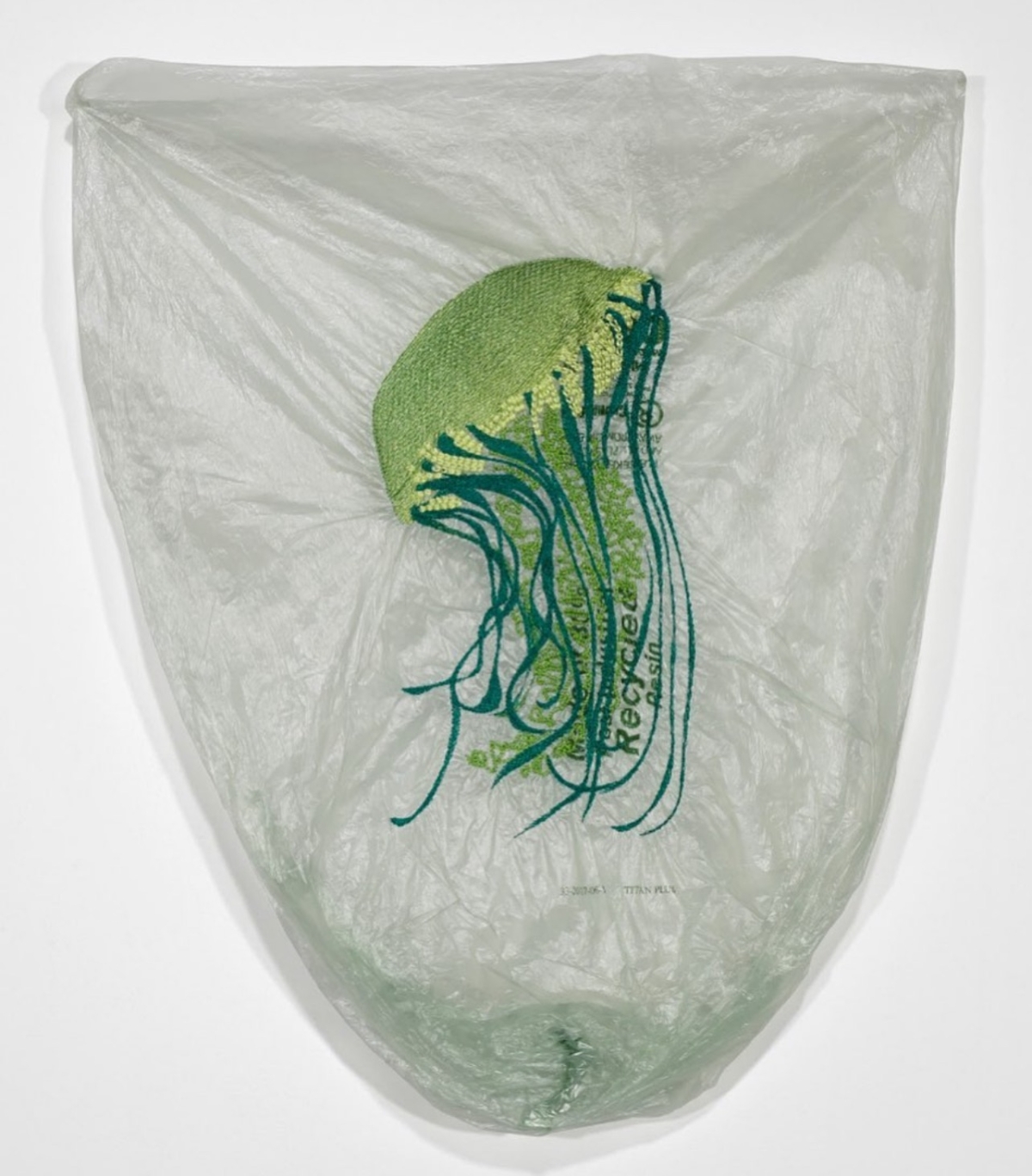 Blue and green embroidery of a jellyfish on plastic bag