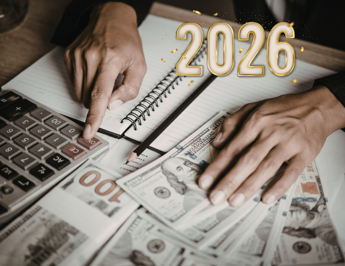 Image of hands over money with an open book and calculator with year 2026 in the corner